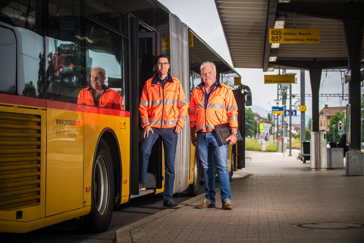 Lukas Steudler und René Iten vor einem Postauto am Bushof Pfäffikon